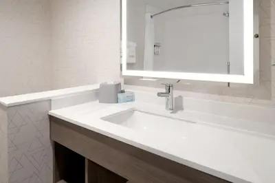 a bathroom with a white sink and a mirror at Holiday Inn Express & Suites - Hollister by IHG in Hollister