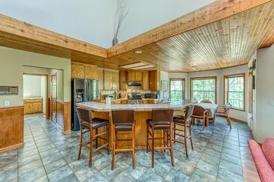 a kitchen with a large island in a room with wooden ceilings at Cascadel Haven in North Fork