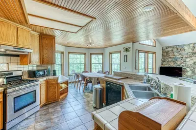 a kitchen with wooden cabinets and a table in it at Cascadel Haven in North Fork