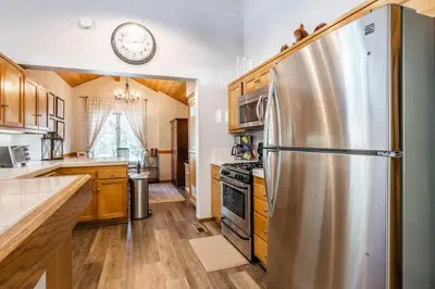 a kitchen with a refrigerator and a clock on the wall at Snowcreek IV 549 in Mammoth Lakes