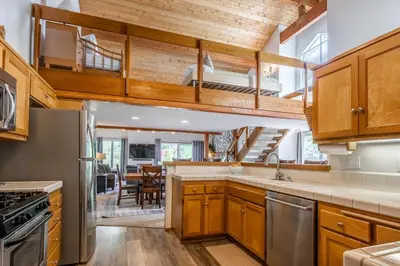 a kitchen with wooden cabinets and a dining room at Snowcreek IV 549 in Mammoth Lakes