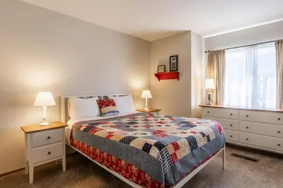 a bedroom with a bed and two lamps and a window at Snowcreek IV 549 in Mammoth Lakes