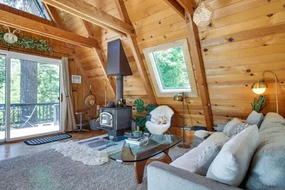 a living room with a couch and a tv in a cabin at Decks, Grills and Fire Pit Camp Connell Hideaway! in Camp Connell