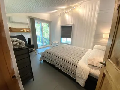 a bedroom with a large bed and a window at Birdwatch Cottage With River Beach Pass in Three Rivers
