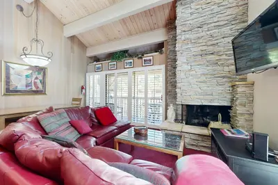 a living room with a leather couch and a fireplace at All-Season Getaway in Kings Beach