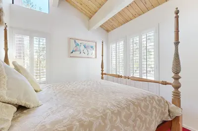 a bedroom with a bed and two windows at All-Season Getaway in Kings Beach