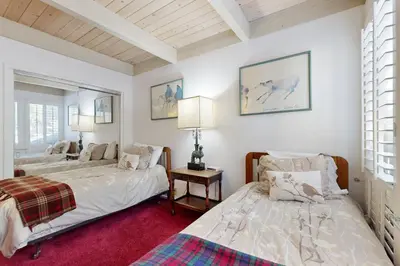 two beds in a room with white walls and a red carpet at All-Season Getaway in Kings Beach