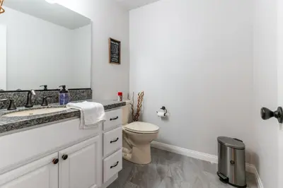 a white bathroom with a toilet and a sink at Boho Townhome in Carson City 10 Mins From Downtown, 30 Mins To Lake Tahoe in Carson City