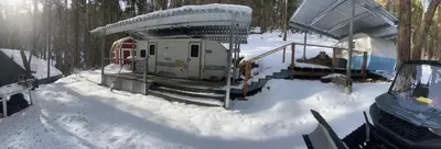 a building in the snow next to a forest at Glamping property in Panorama Heights