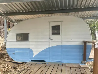 a blue and white trailer sitting under a roof at Glamping property in Panorama Heights