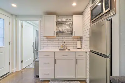 a kitchen with white cabinets and a stainless steel refrigerator at Ski and Hike Cozy Dtwn Reno Studio with Fireplace in Reno