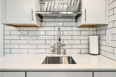 a kitchen with a sink and white tiled walls at Ski and Hike Cozy Dtwn Reno Studio with Fireplace in Reno