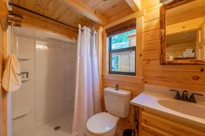 a bathroom with a toilet and a shower and a sink at Casa de Fruta Cabins, Inn & RV Park in Hollister