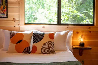 a bedroom with a bed with pillows and a window at Casa de Fruta Cabins, Inn & RV Park in Hollister