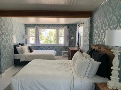 a bedroom with two beds and a window at The Bodie Hotel in Bridgeport