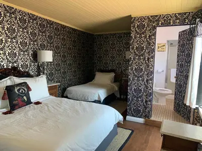 a hotel room with two beds and a bathroom at The Bodie Hotel in Bridgeport