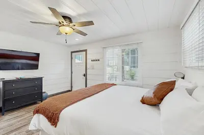 a white bedroom with a bed and a ceiling fan at Manzanita Holiday 3 in South Lake Tahoe