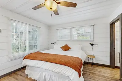 a white bedroom with a bed and a ceiling fan at Manzanita Holiday 3 in South Lake Tahoe