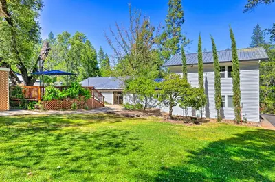 a white house with a yard and a fence at Steps to Dtwn Murphys Cottage with Furnished Porch in Murphys
