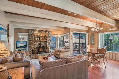 a living room with couches and a stone fireplace at Val D'Isere at the Village by 101 Great Escapes in Mammoth Lakes