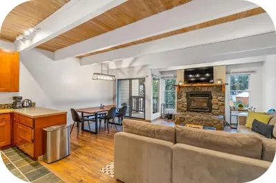 a kitchen and living room with a couch and a fireplace at Val D'Isere at the Village by 101 Great Escapes in Mammoth Lakes