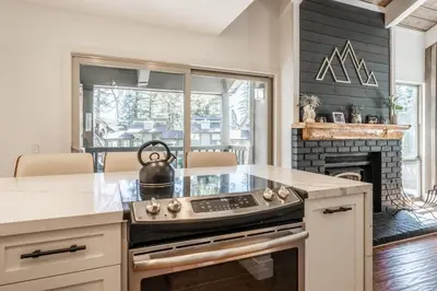 a kitchen with a stove top oven next to a fireplace at Chamonix 24 is a 2bed plus loft 3 bath Upgraded Canyon Ldge Nearly Ski in Ski Out Sleeps 8 in Mammoth Lakes