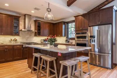 a kitchen with wooden cabinets and a stainless steel refrigerator at Gray Bear #86 home in Mammoth Lakes