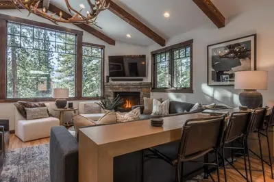 a living room with a table and chairs and a fireplace at Gray Bear #86 home in Mammoth Lakes
