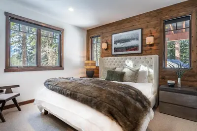 a bedroom with a large bed and windows at Gray Bear #86 home in Mammoth Lakes
