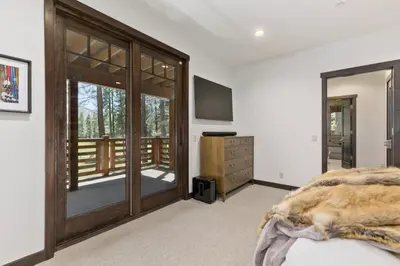 a bedroom with a wooden door and a balcony at Gray Bear #86 home in Mammoth Lakes