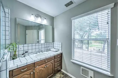 a bathroom with a sink and a mirror and a window at Charming Home Less Than 10 Mi to Sequoia Natl Park! in Three Rivers