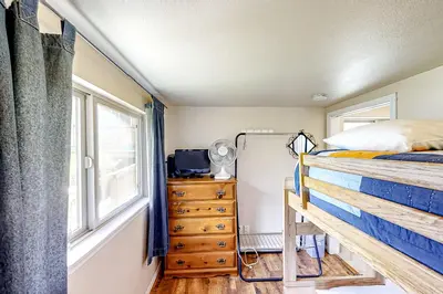 a bedroom with a bed and a dresser and a window at Lakefront Retreat in Bass Lake