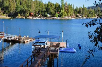 a dock with a boat on a lake at Lakefront Retreat in Bass Lake