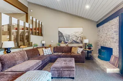 a living room with a couch and a stone wall at Huntington Lake Condo #102 in Lakeshore