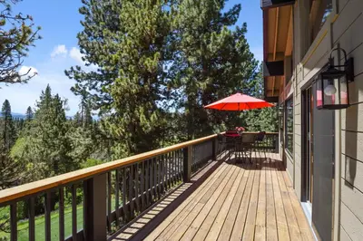 a balcony with a table and an umbrella at 17th Tee Lake Tahoe Retreat in Incline Village