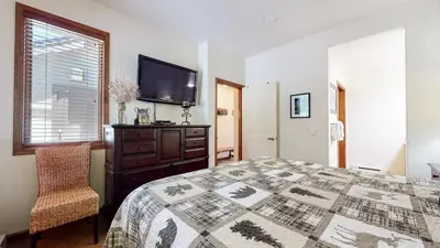 a bedroom with a bed and a flat screen tv at Eagle Run #114 condo in Mammoth Lakes