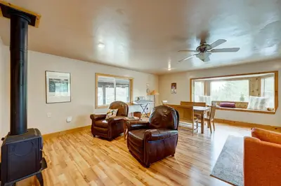 a living room with a wood stove and leather chairs at Toast of the Mountain Town in Truckee
