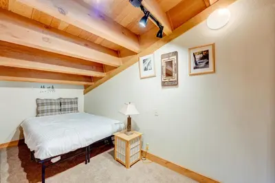 a bedroom with a bed and a table with a lamp at Pine Time in Truckee
