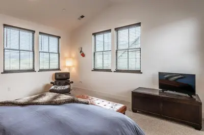 a bedroom with a bed and a tv and windows at Creekhouse 1334 in Mammoth Lakes