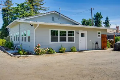 a small white house with a driveway at Charming Lodi Retreat Walk to Local Wineries in Lodi