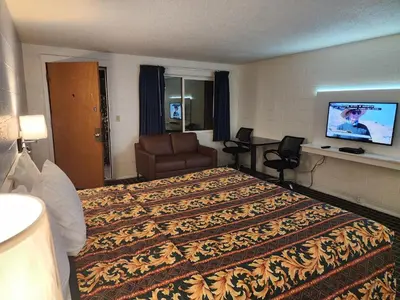 a hotel room with a large bed and a television at Holiday Lodge in Hawthorne