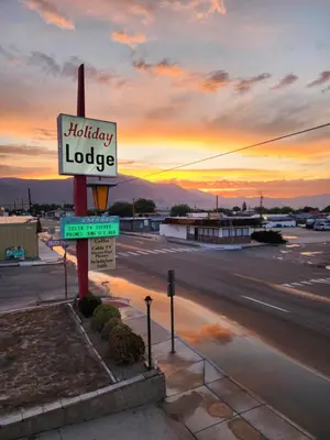 a sign for a holiday lodge in a parking lot at Holiday Lodge in Hawthorne