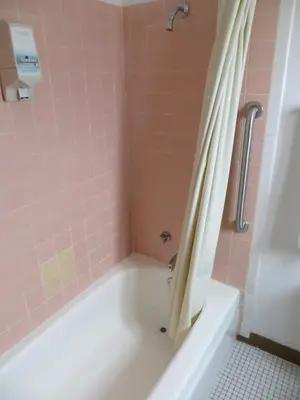 a bathroom with a bath tub with a shower curtain at Holiday Lodge in Hawthorne