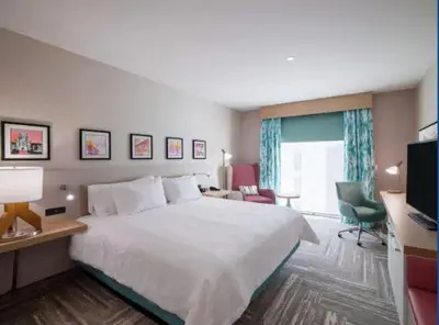 a hotel room with a large bed and a desk at Hilton Garden Inn Visalia, Ca in Visalia