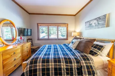a bedroom with a bed and a dresser and a mirror at Mountainback 100 in Mammoth Lakes