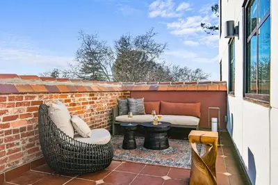 a patio with a table and chairs on a brick wall at Hyatt House Sacramento-Midtown in Sacramento
