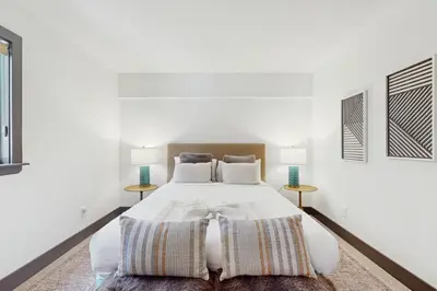a white bedroom with a large bed with two tables at Bennett Flat Adventure in Truckee