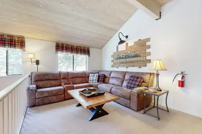 a living room with a brown couch and a table at Falcon Point Pines in Truckee