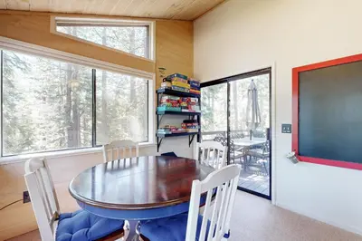 a dining room with a table and chairs and a chalkboard at Falcon Point Pines in Truckee