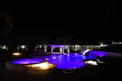 a swimming pool lit up at night with purple lights at 4BR LUXURY ENTERTAINMENT OASIS in Tracy